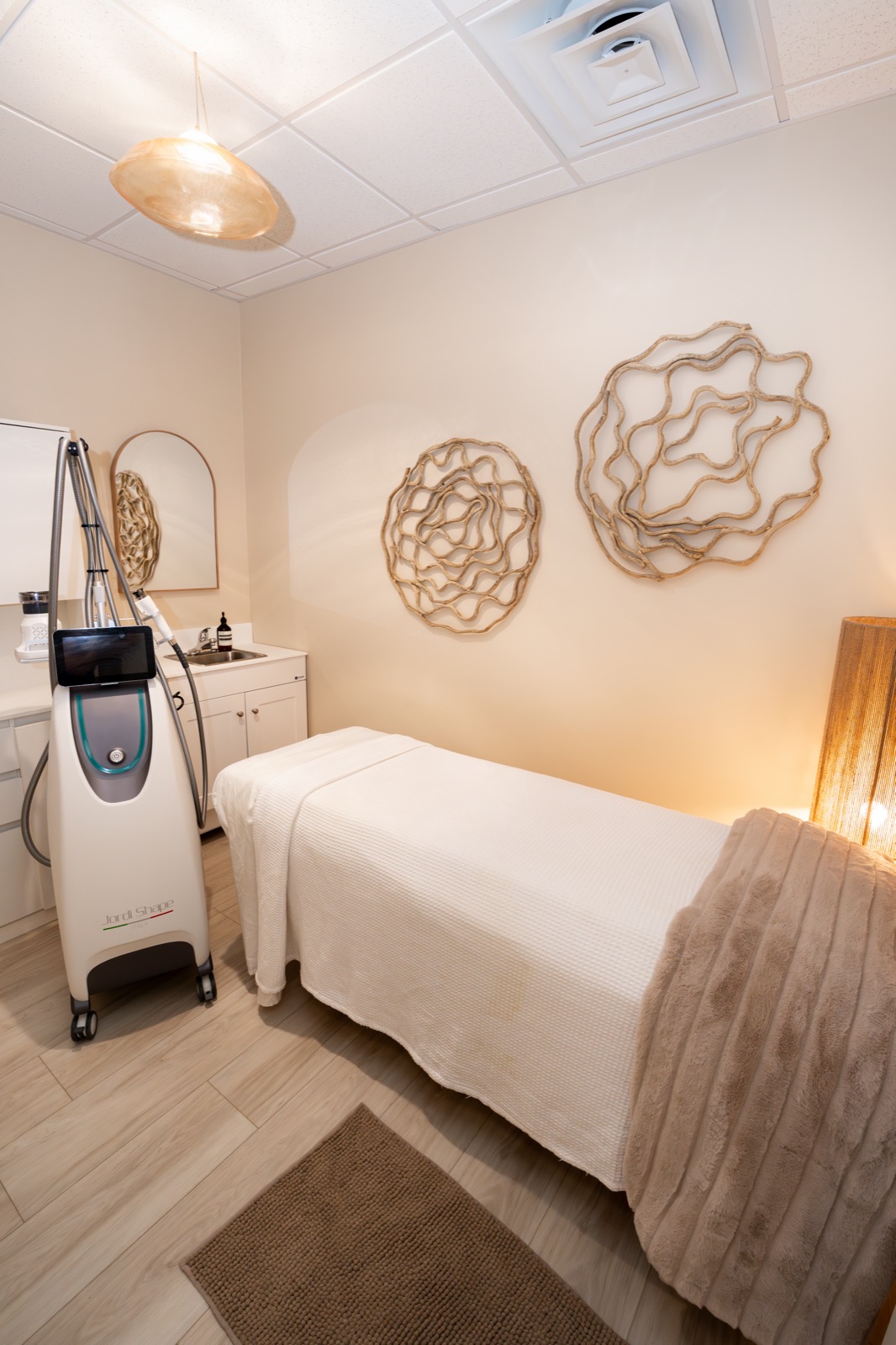 Private treatment room at Rêve Wellness with a treatment table, device and warm lighting