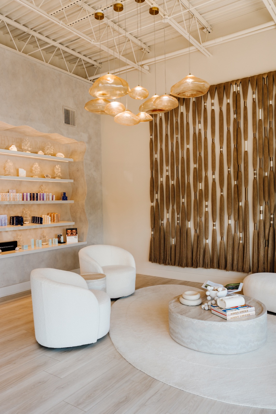 Rêve Wellness lounge in Sandy Springs with a woven wall piece, amber glass pendants and white seating