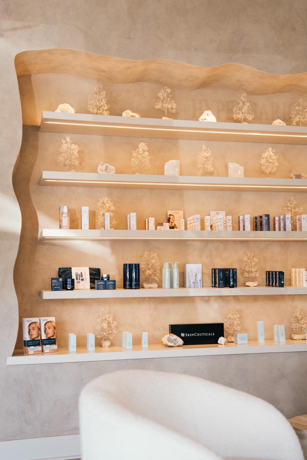 Curated skincare products on lit wall shelves at Rêve Wellness