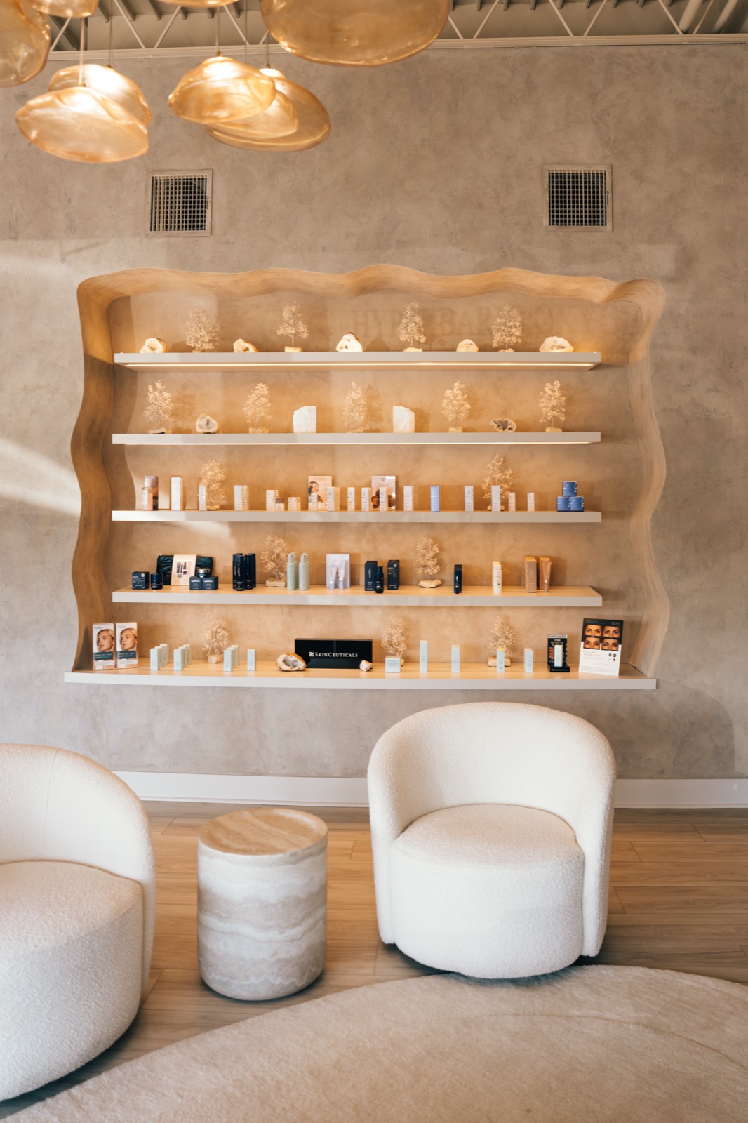 Skincare shelves and white lounge chairs in the Rêve Wellness reception