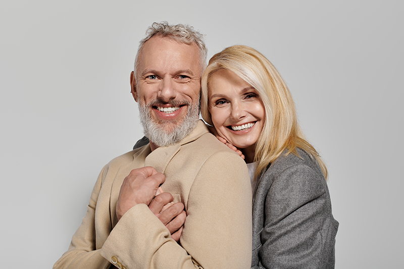 A joyful senior couple shares a loving moment, dressed in elegan